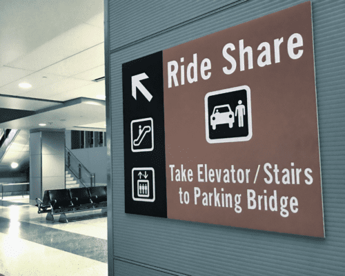 A sign with an arrow that points to a Rideshare Pickup area.