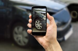 Man photographing his vehicle damages for accident insurance