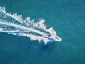A boat making its way through blue water.